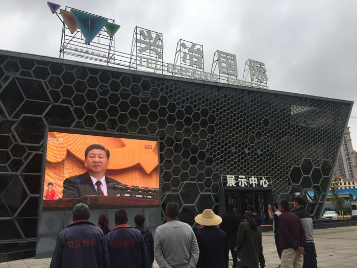 兴冶国际售楼部大屏直播十九大开幕盛况引路人驻足观看